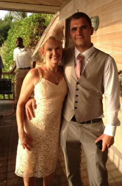 Woman in lace dress and man in suit, posing together.