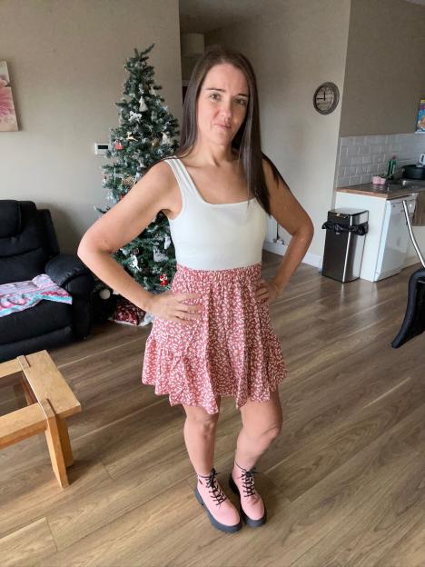 Woman in a white and pink dress and pink boots.