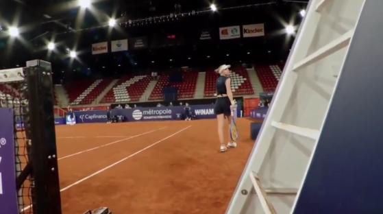 Tennis player on a court in an arena.