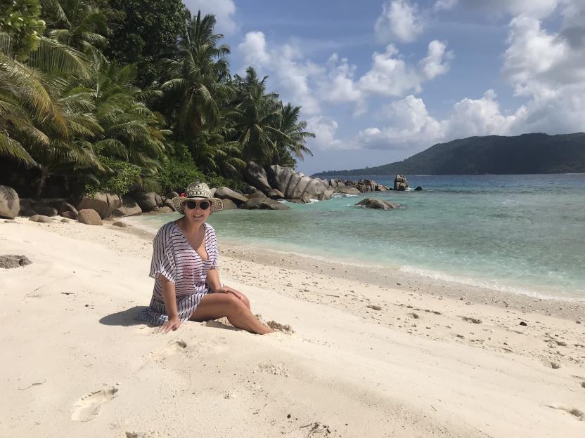 Woman sitting on a Seychelles beach.
