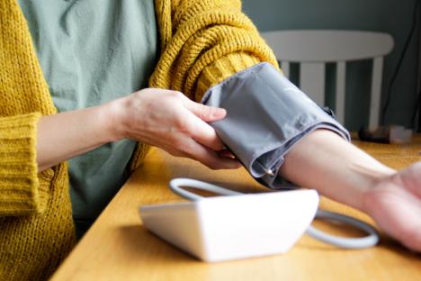 Woman using a blood pressure monitor.