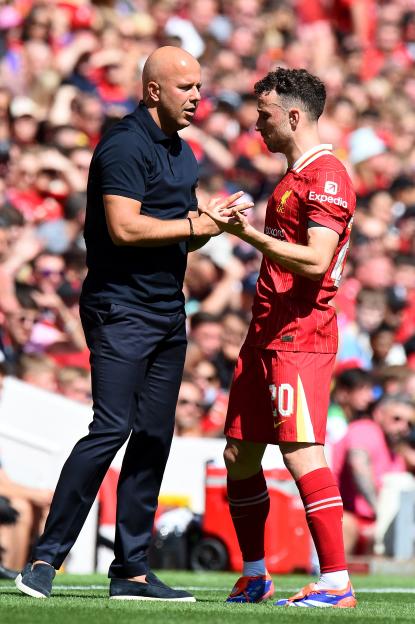 Liverpool's manager Arne Slot talking to Diogo Jota during a soccer match.