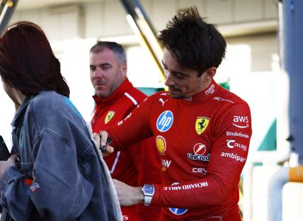 Charles Leclerc signing an autograph.