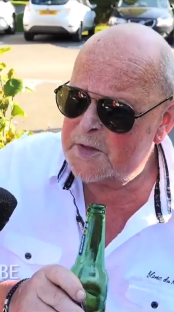 Man in sunglasses holding a beer bottle.