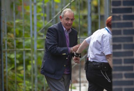 John Allen, a child abuser, handcuffed and escorted from prison to court.