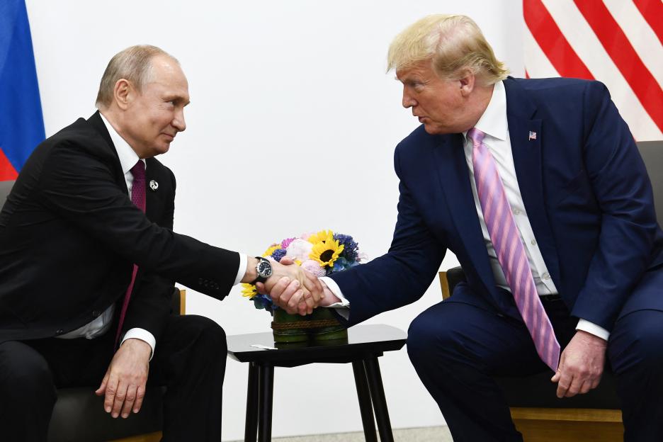 Presidents Putin and Trump shaking hands at a meeting.