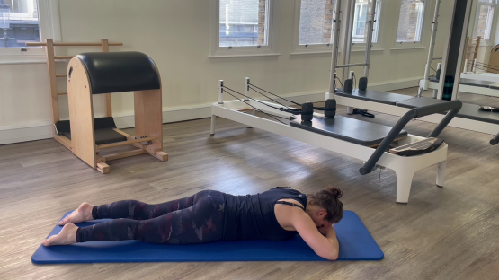 Woman doing Pilates exercise on mat.