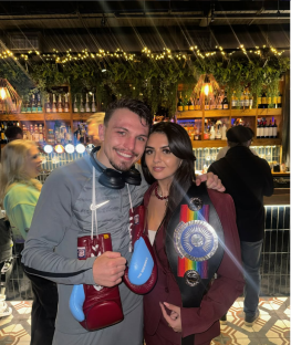 A boxer and a woman holding a championship belt.