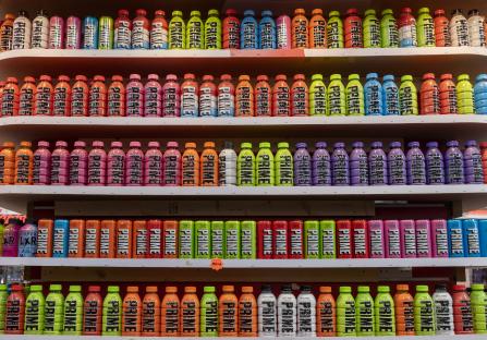 A shelf stocked with various Prime Hydration drinks in different flavors.