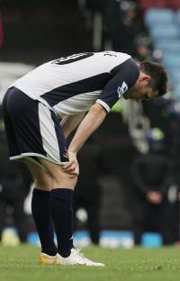 Robbie Keane of Tottenham Hotspur looking dejected on a soccer field.