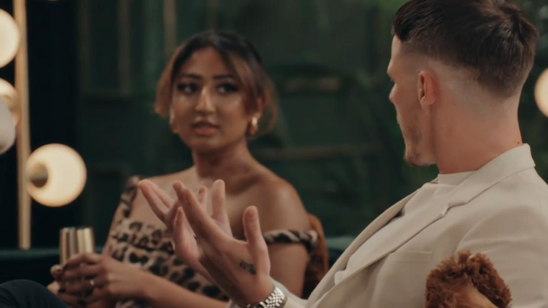 Steven and Nelly sitting and talking, with Steven gesturing with his hands.