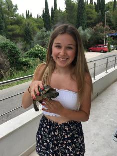 Teenage girl holding a small tortoise.