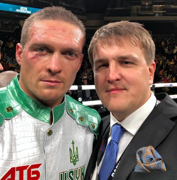 Boxer Oleksandr Usyk with red marks on his face stands next to his promoter, Alexander A. Krassyuk.