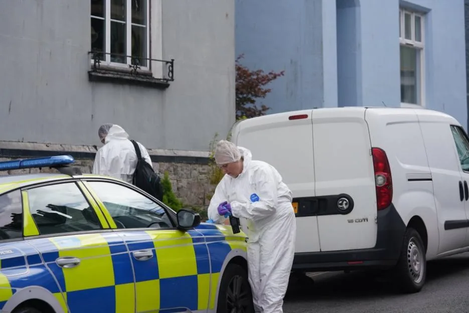 Police forensics officers in protective suits work at the scene of an incident on Newcomen Road in Dartmouth.
