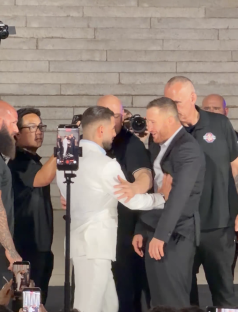 Two men in suits being separated by security.