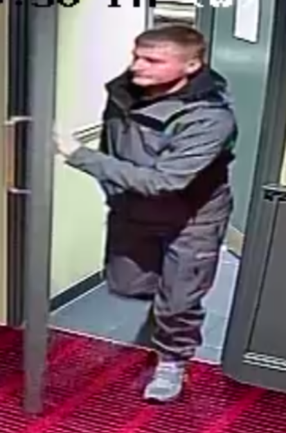 CCTV image of a man in a grey jacket exiting a door, leaving without paying a £329 bill.