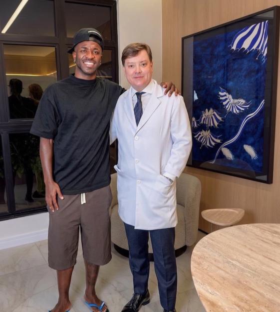 Vinicius Jr. with a man in a white lab coat.