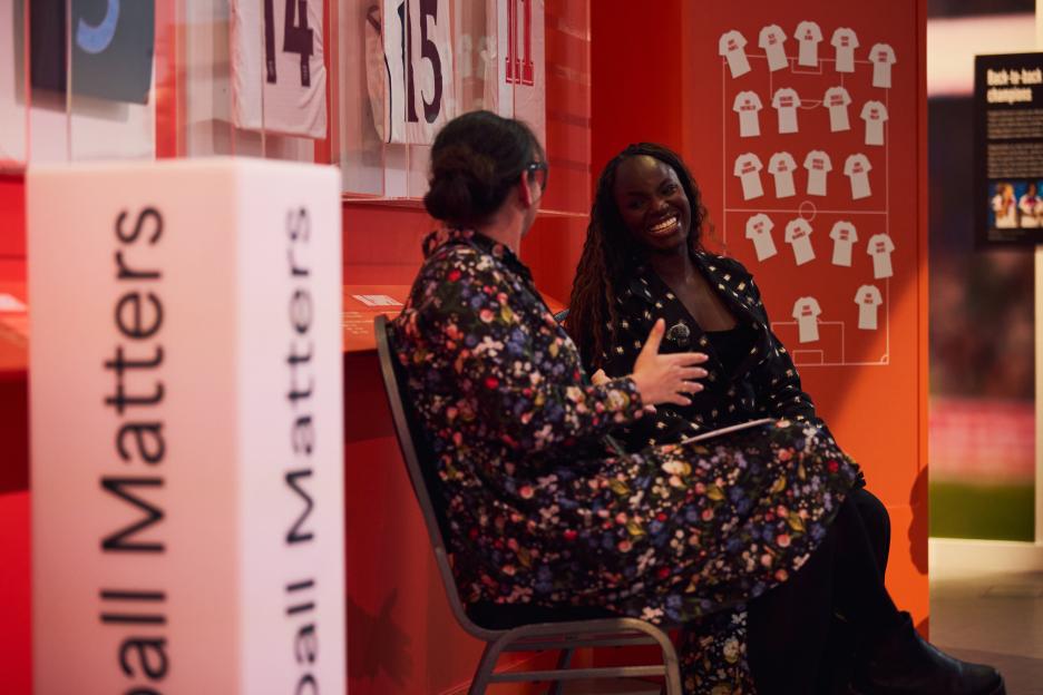 Two women sitting and talking at an event about Football Matters.