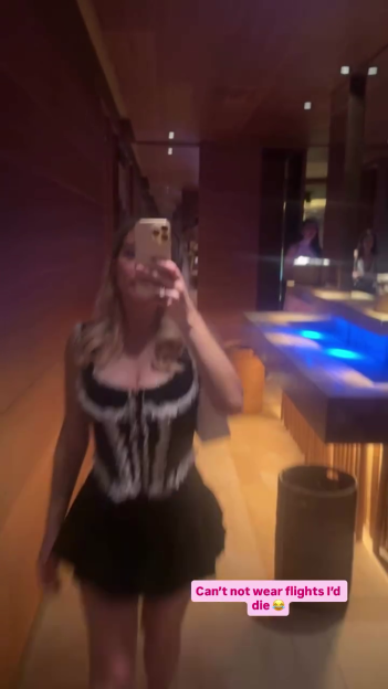 Helen Flanagan taking a mirror selfie, wearing a black and white corset top and black skirt.