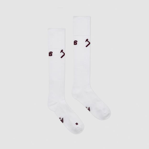 A pair of white, knee-high socks with a maroon New Balance logo on the shin.