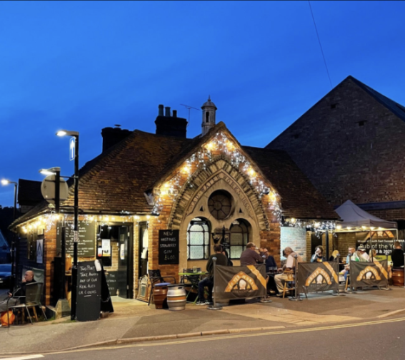 Rye Waterworks micropub at night with outdoor seating.