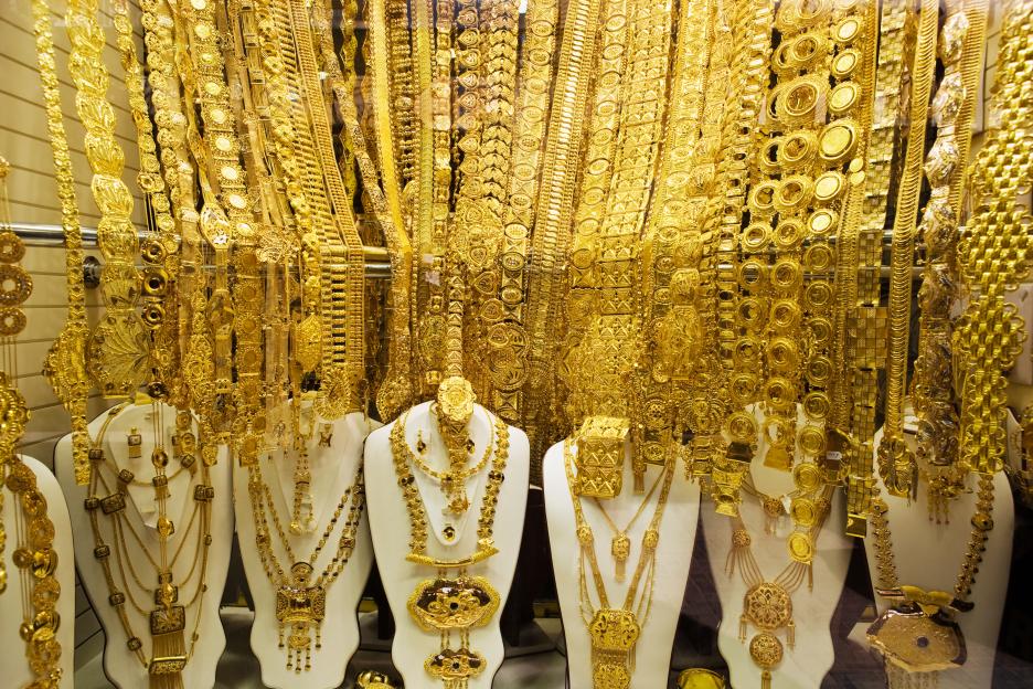 Intricate gold necklaces and jewelry on display in a store.