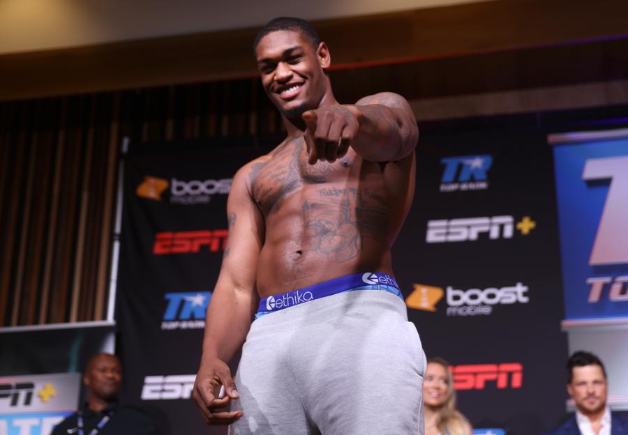 Jared Anderson smiling and pointing at the camera during a weigh-in.