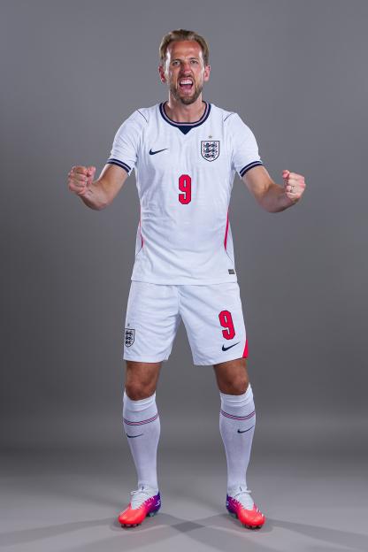 Footballer Harry Kane wearing an England uniform and clenching his fists.