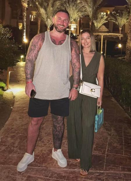 James Bainbridge and Jessica Hill smiling together at night outdoors.