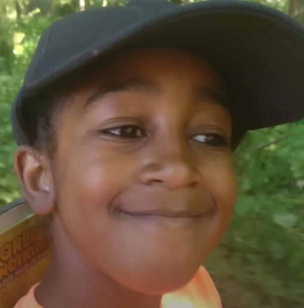 Adam Henry as a child, wearing a black cap.