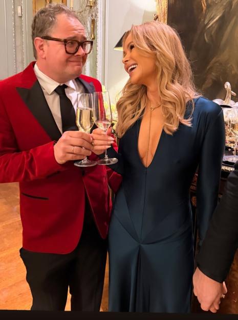 Amanda Holden and Alan Carr toasting champagne.