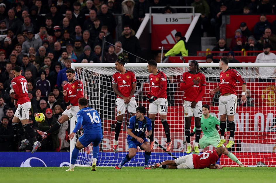 A group of Manchester United players in red jerseys defending their goal against Bournemouth players during a football match.