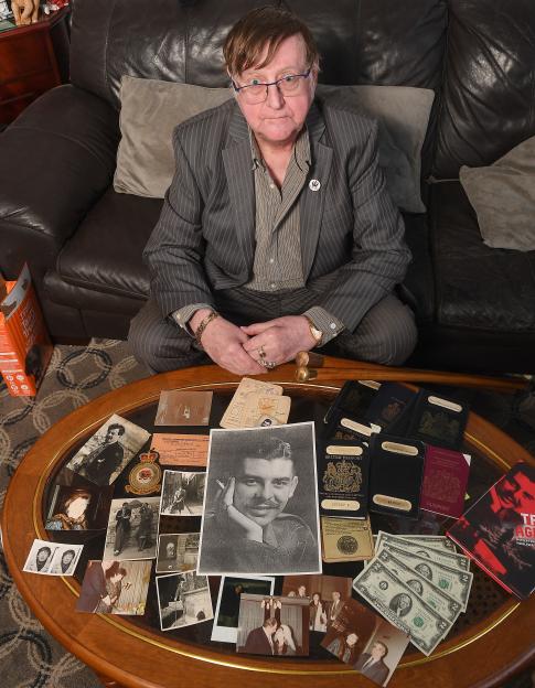 Robin Maudsley sits with memorabilia, photographs, passports, and money belonging to his spy cousin, William Maxwell Nasmyth Wilcock.