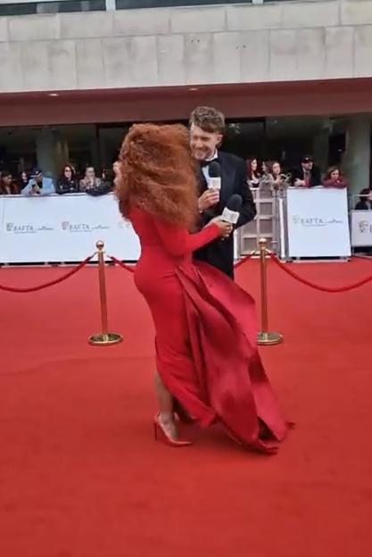 Fleur East battling howling wind on the TV Baftas' red carpet.