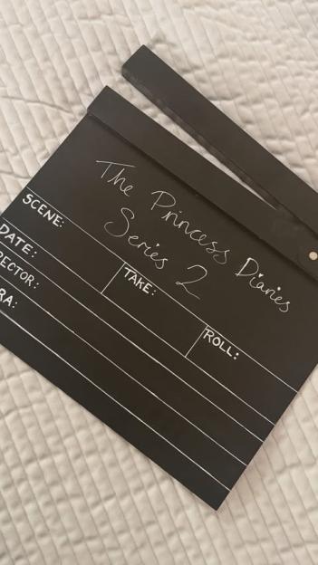 A black clapperboard with "The Princess Diaries Series 2" written on it.