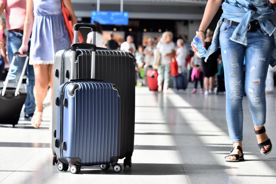 Two plastic travel suitcases in the airport hall