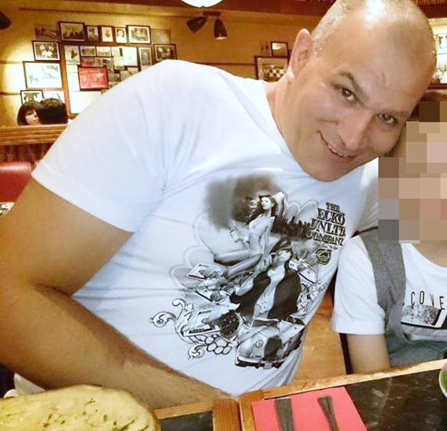 Geraint Berry, a bald man with a receding hairline, wearing a white t-shirt, smiles at the camera.