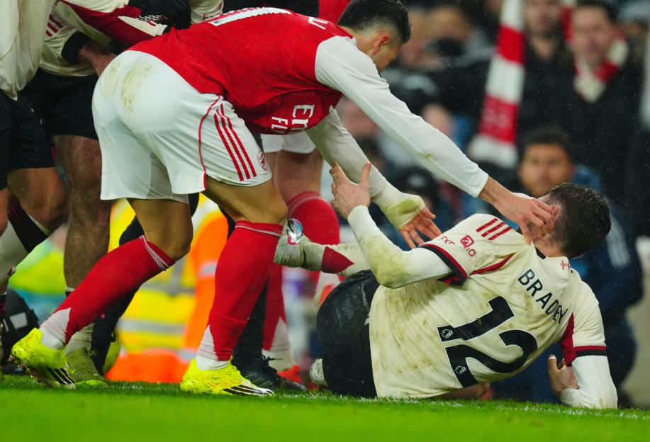 Arsenal's Gabriel Martinelli helps Liverpool's Conor Bradley up after an injury.