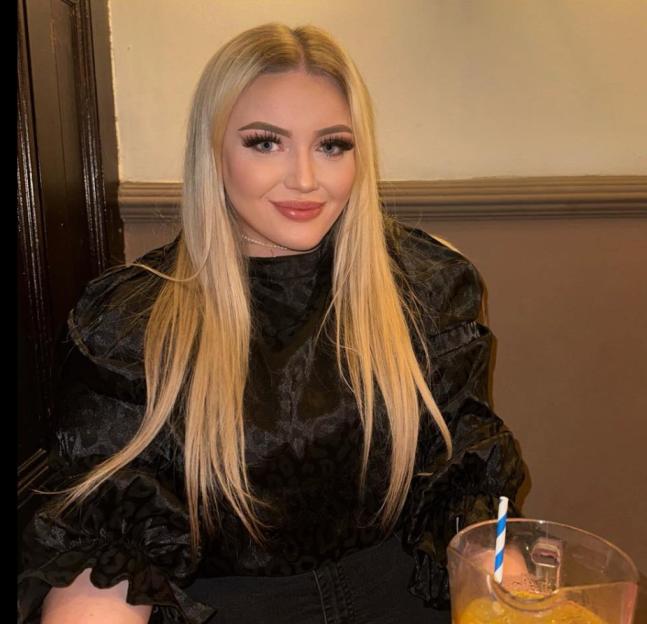 Hannah Bloor, a woman with long blonde hair, wearing a black top.