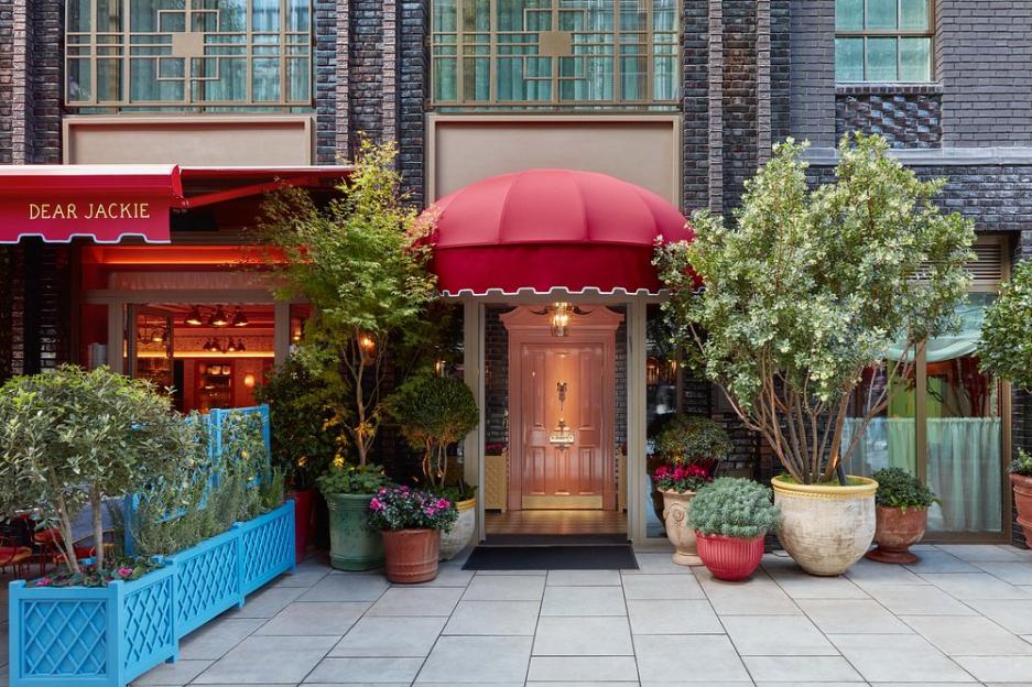 Exterior of Flute Bar in Soho, with a red awning over the entrance and a "Dear Jackie" sign over another entrance.