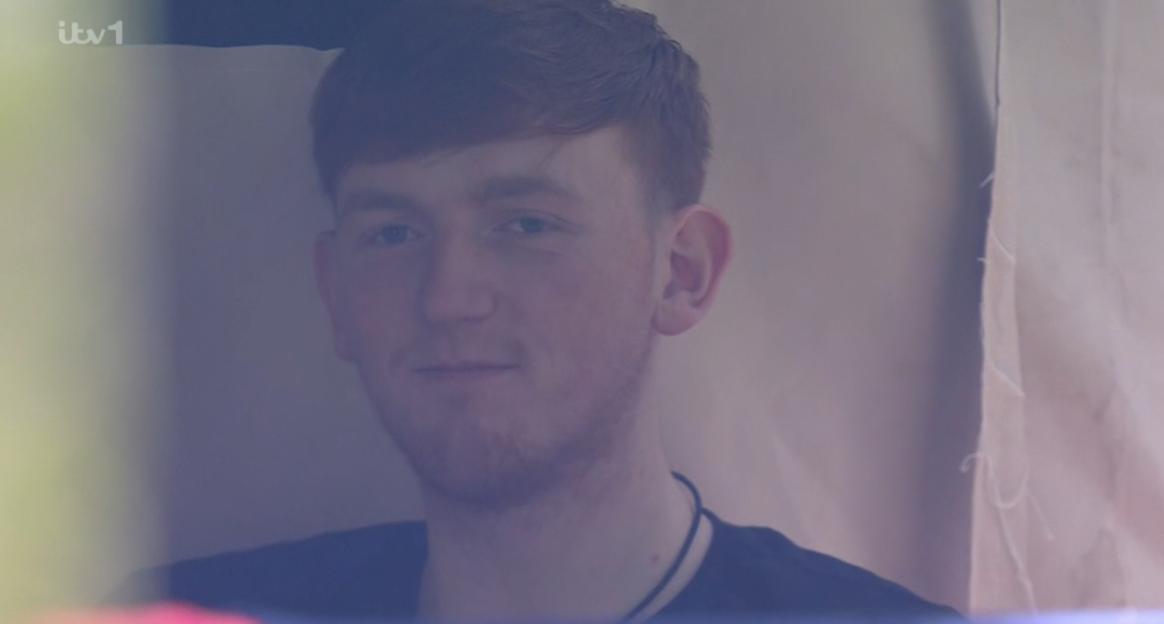 A young man with light reddish-brown hair and a short beard looks directly at the camera, slightly smiling.