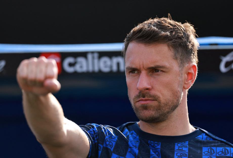 Three Arsenal soccer players, Santi Cazorla, Laurent Koscielny, and Aaron Ramsey, celebrating with the FA Cup trophy.