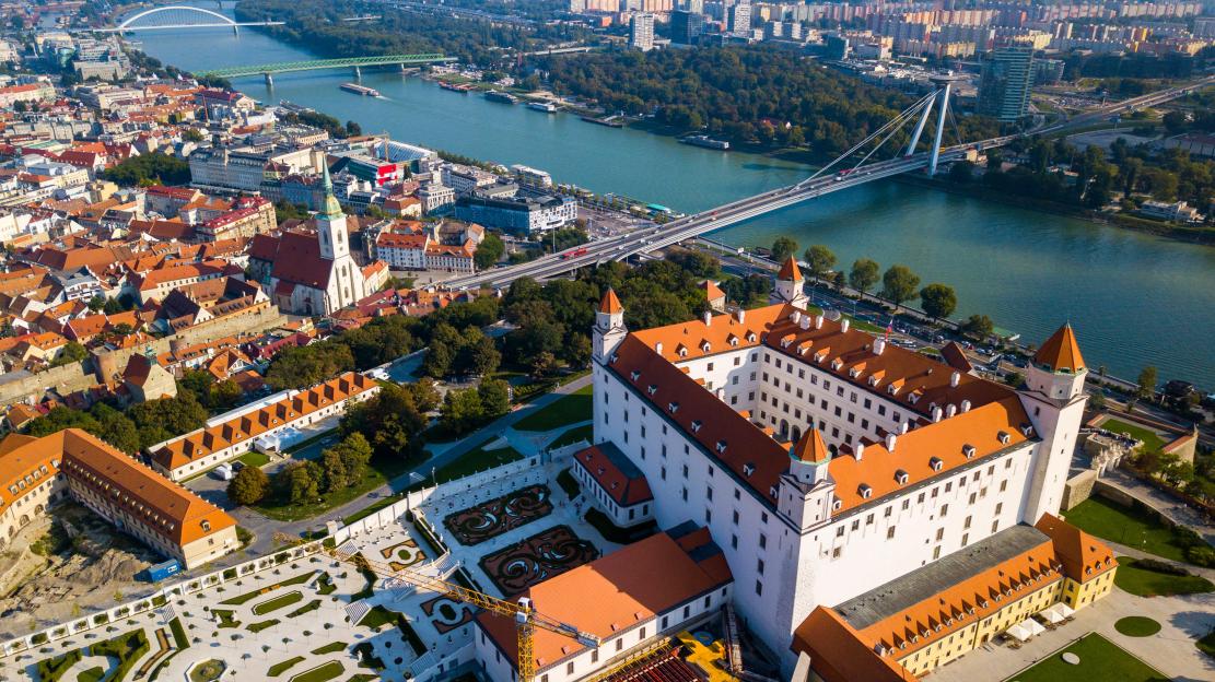 Aerial view of Bratislava Castle and the city with the Danube River and bridges.