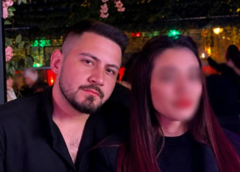 A man with a beard and faded haircut next to a woman whose face is blurred.