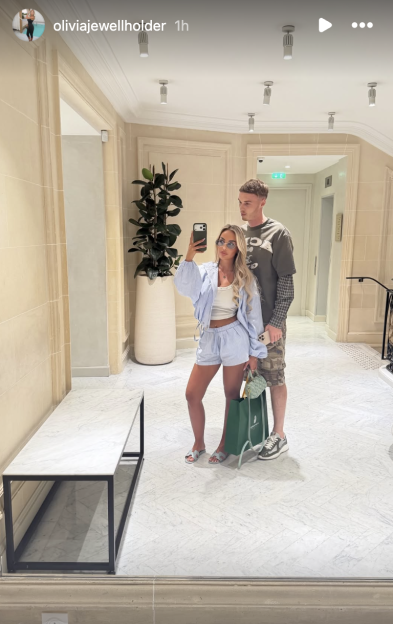 Olivia Jewell Holder and a man posing for a mirror selfie.