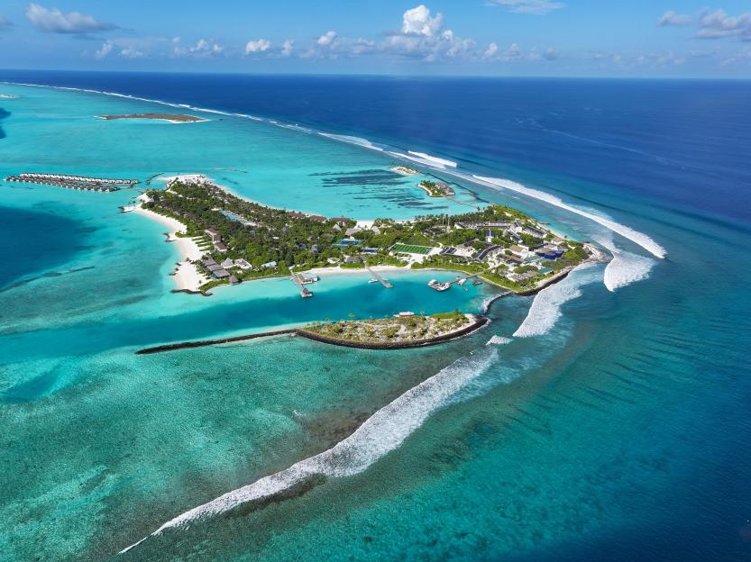 Aerial view of the Thulusdhoo island resort in the Maldives with a surf spot known as Chickens.