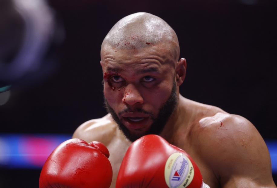 Chris Eubank Jr. in the boxing ring, with cuts and blood on his face, head, and shoulder.