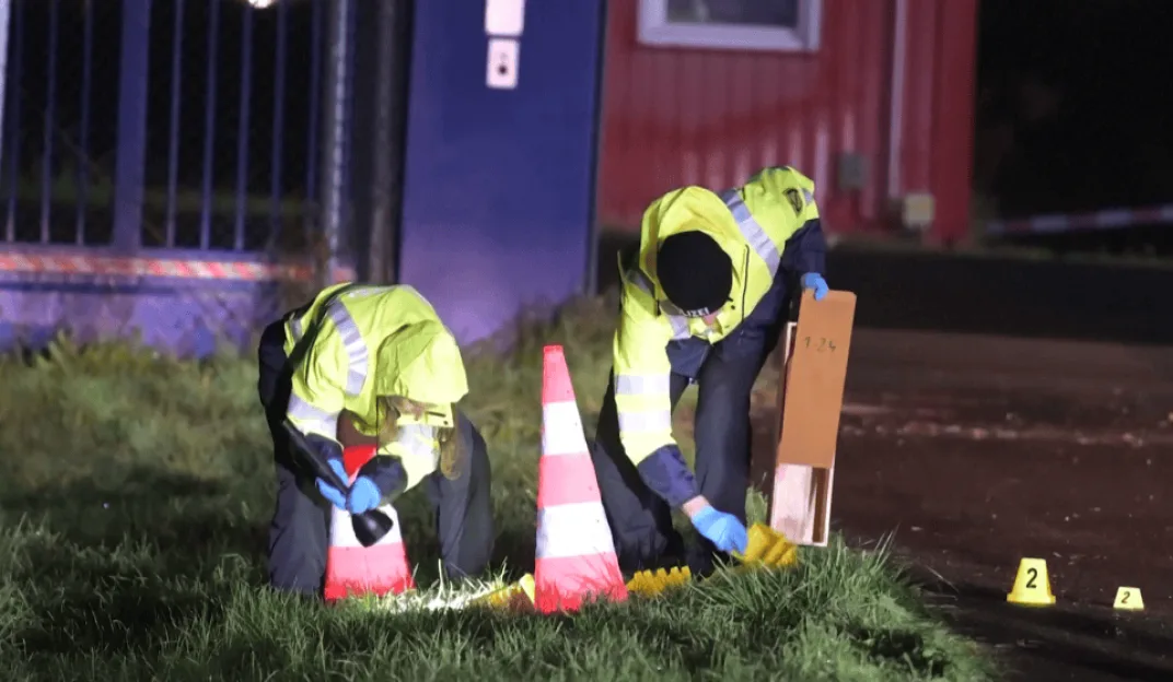 Police investigators inspect the breached fence at Leipzig Airport at night.