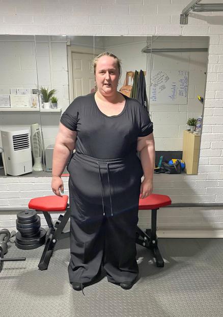 Woman in black workout clothes in a gym.