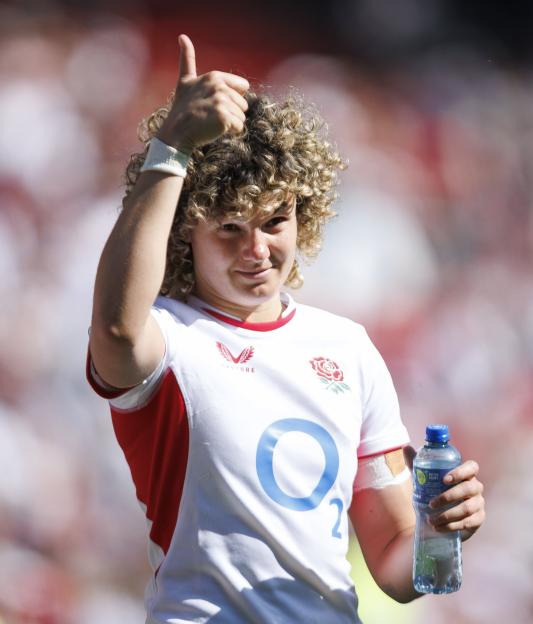 England rugby player gives a thumbs up while holding a water bottle.